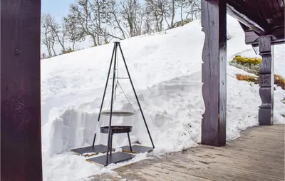 a chair sitting on a porch in the snow at Beautiful Home In Rauland With Sauna in Rauland
