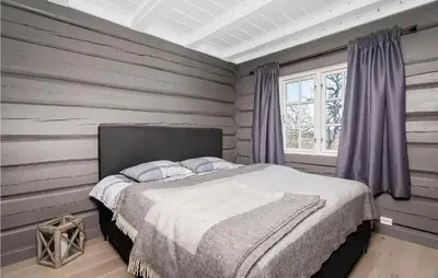 a bedroom with a bed in a room with wooden walls at Beautiful Home In Rauland With Sauna in Rauland