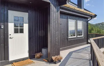a wooden cabin with a white door and a deck at Awesome Home In Rauland With Wifi in Rauland
