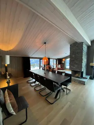 a dining room with a table and chairs and a fireplace at Gausta Residence in Gaustablikk