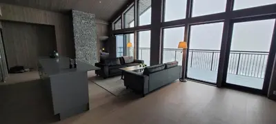 a living room with a couch and chairs and windows at Gausta Residence in Gaustablikk
