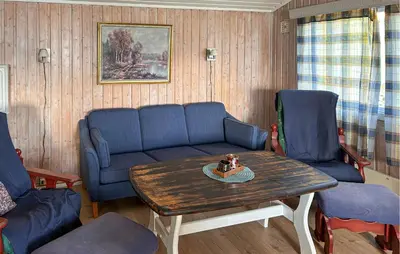 a living room with a couch and a table and chairs at 3 Bedroom Awesome Home In Vikersund in Vikersund