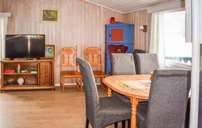 a living room with a table and chairs and a television at 3 Bedroom Awesome Home In Vikersund in Vikersund