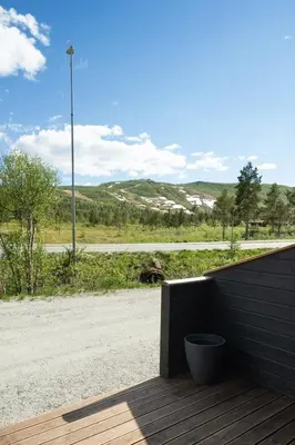 a wooden deck with a view of a road at Flott leilighet i Vestlia - ski in/ski out in Geilo
