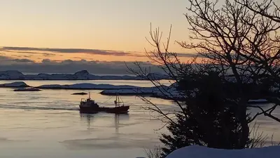 a boat sitting in the water at sunset at Apartment , Øygarden, Bergen in Torsteinsvik