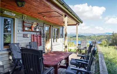 a wooden table and chairs on the porch of a house at Gorgeous Home In Aksdal With Kitchen in Aksdal