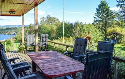 a wooden table and chairs on a deck at Gorgeous Home In Aksdal With Kitchen in Aksdal