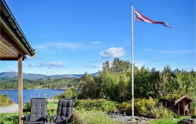 two chairs and an american flag next to a lake at Gorgeous Home In Aksdal With Kitchen in Aksdal