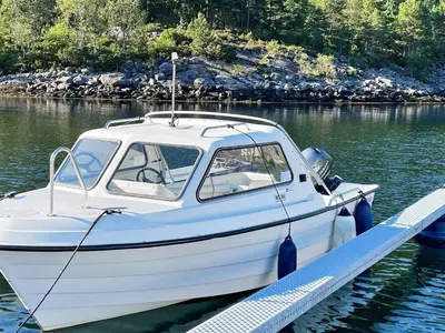 a white boat docked at a dock in the water at 4 person holiday home in Svelgen-By Traum in Sørgulen