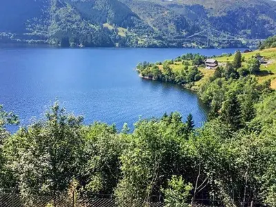 a view of a large blue lake with trees at 8 person holiday home in Bruvik-By Traum in Bruvik