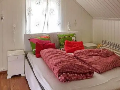 a bed with red and green blankets and a window at 8 person holiday home in Bruvik-By Traum in Bruvik