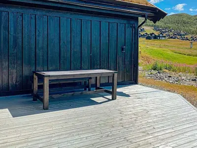 a wooden bench sitting on a deck next to a building at 10 person holiday home in Rauland-By Traum in Rauland