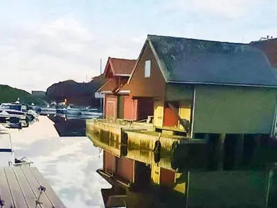 a house sitting on the water next to a marina at 6 person holiday home in Hernar-By Traum in Bøvågen