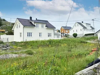 a group of houses on a hill with grass at 6 person holiday home in Hernar-By Traum in Bøvågen