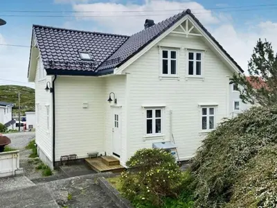 a white house with a black roof at 6 person holiday home in Hernar-By Traum in Bøvågen