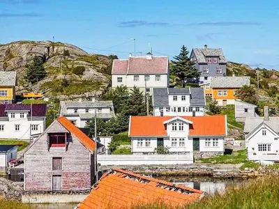 a small town with houses and a body of water at 6 person holiday home in Hernar-By Traum in Bøvågen