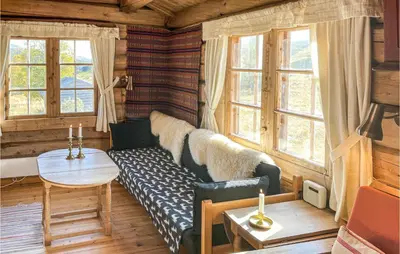 a living room with a couch and a table and windows at 3 Bedroom Nice Home In Kvam in Kvam