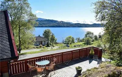 a balcony with a table and chairs and a view of a lake at Nice Home In Os With House Sea View in Oma