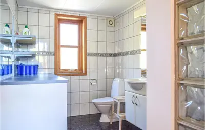 a bathroom with a toilet and a sink at Nice Home In Os With House Sea View in Oma