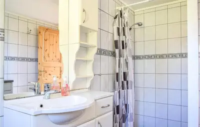 a bathroom with a sink and a shower at Nice Home In Os With House Sea View in Oma