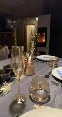 a table with wine glasses and a candle on it at Seterhytte i Havsdalen in Geilo