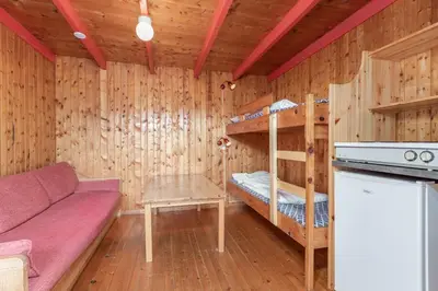 a living room with a couch and bunk beds at Pluscamp Sandvik in Gaupne