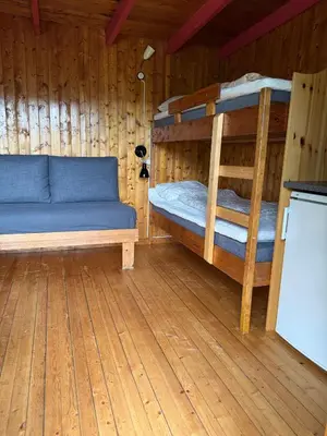 a room with two bunk beds in a wooden cabin at Pluscamp Sandvik in Gaupne