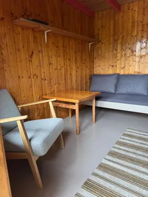 a room with a bench and a table and chairs at Pluscamp Sandvik in Gaupne