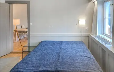 a large blue bed in a room with a window at Stunning Apartment In Lillehammer in Lillehammer
