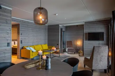 a living room with a yellow couch and a table at Riddertunet apartment 101 in Beitostøl