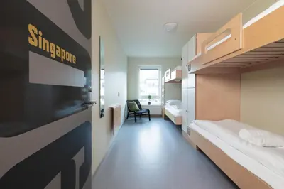 a room with two bunk beds and a door at Rumi Hostel in Trondheim