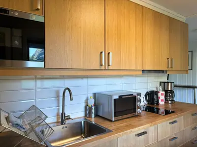a kitchen counter with a sink and a microwave at Brekke Apartments in Flåm