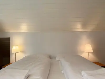 two white beds in a bedroom with two lamps at Brekke Apartments in Flåm