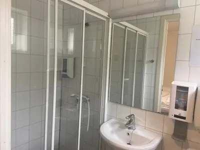 a bathroom with a shower and a sink and a mirror at Brekke Apartments in Flåm