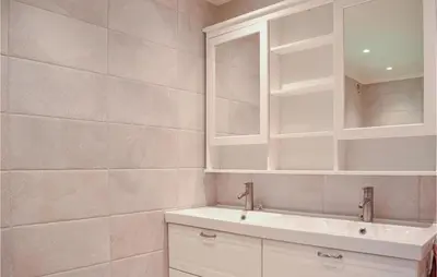 a white bathroom with a sink and a mirror at 4 Bedroom Lovely Home In Strandebarm in Strandebarm