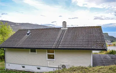 a white house with a roof on top of it at 4 Bedroom Lovely Home In Strandebarm in Strandebarm
