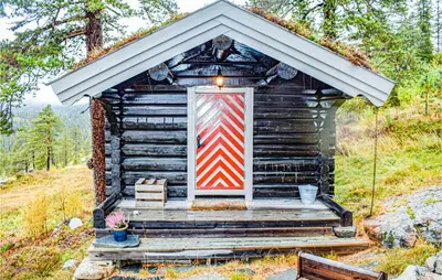 a small log cabin with a red and white door at 4 Bedroom Pet Friendly Home In Eggedal in Eggedal