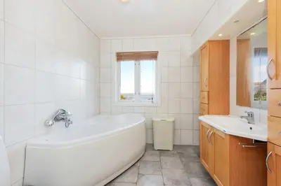 a white bathroom with a tub and a sink at Flemsøy in Ålesund