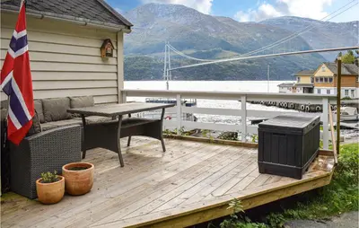 a wooden deck with a table and a grill at 2 Bedroom Cozy Home In Vallavik in Kaland