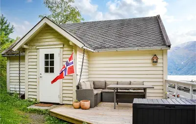 a small shed with a picnic table and a flag at 2 Bedroom Cozy Home In Vallavik in Kaland