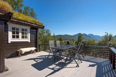 a patio with a table and chairs on a deck at Økslevegen 2 in Stranda