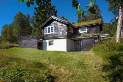 a house with a grass roof on top of a field at Økslevegen 2 in Stranda