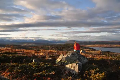 a person sitting on a rock on a hill at Bualie Golsfjellet in Gol