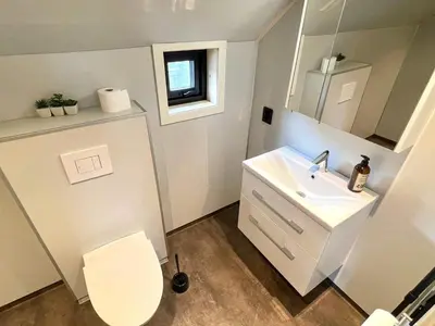 a bathroom with a white toilet and a sink at 7 person holiday home in Huglo-By Traum in Nordhuglo