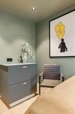 a bedroom with a dresser and a chair and a picture at Odda Panorama in Odda