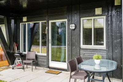 a patio with a glass table and chairs at Leilighet Beitostølen sentrum, terrasse og innendørs parkering in Beitostøl