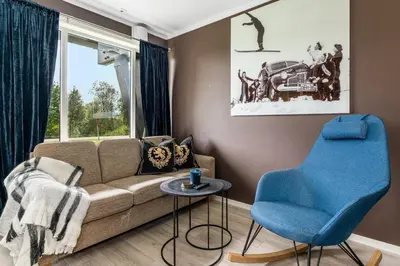 a living room with a couch and a blue chair at Leilighet Beitostølen sentrum, terrasse og innendørs parkering in Beitostøl