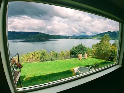 a view of a lake from a window at Bergen Sunrise Terrace Apartment in Bergen