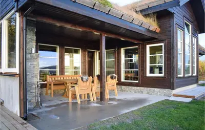 a patio with a table and chairs on a house at Lovely Home In Hjartdal With Sauna in Hjartdal