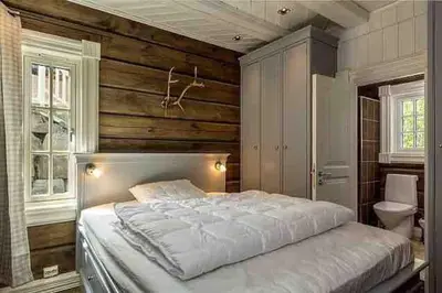 a bedroom with a large bed and wooden walls at Stor og eksklusiv tømmerhytte Hemsedal in Grøndalen